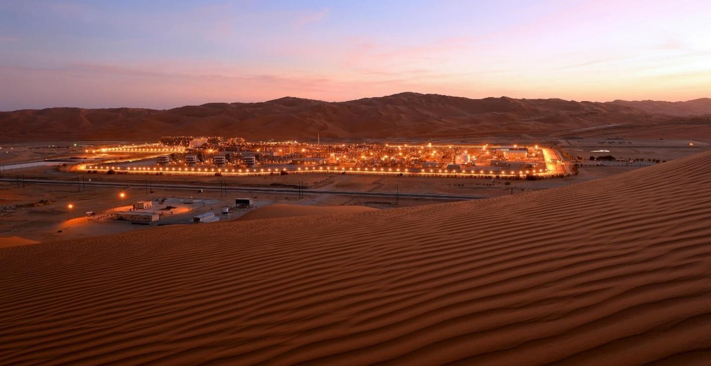 SAZEC GROUP illuminated desert pipeline and industrial facility at dusk
